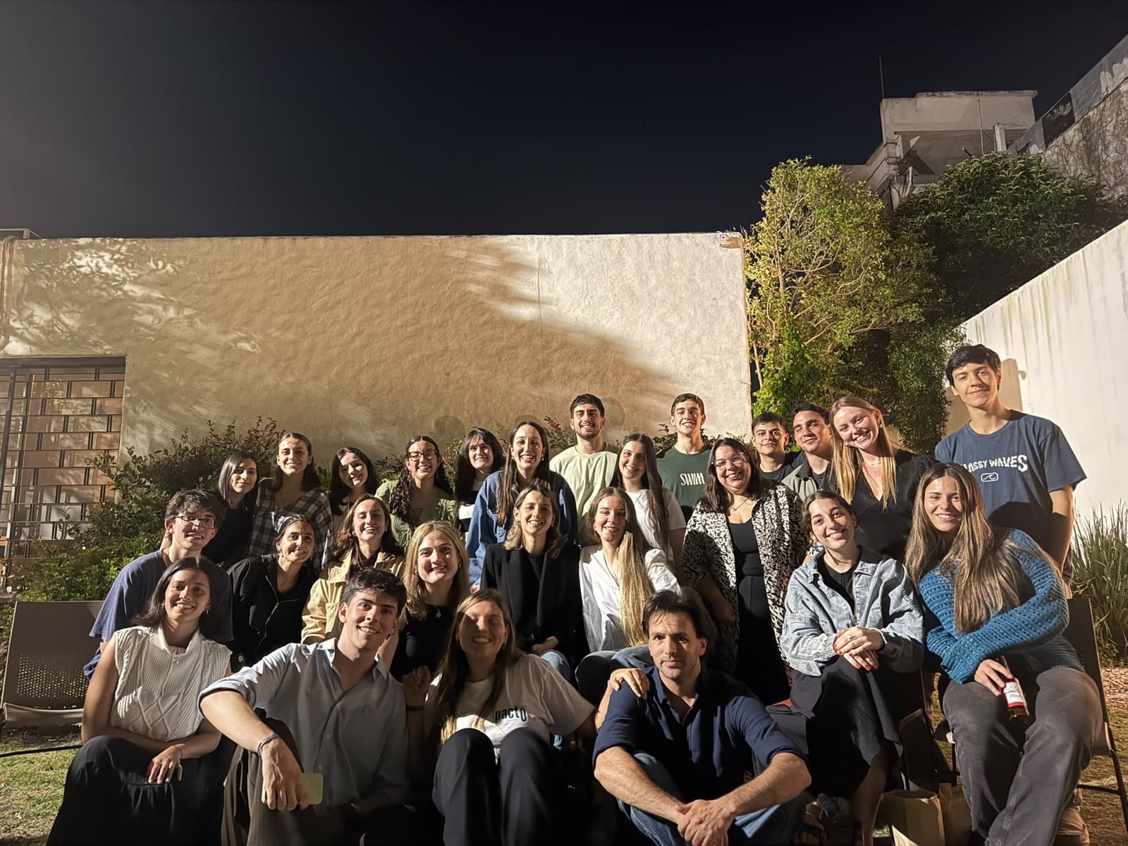 Foto grupal del equipo de Pacto en un encuentro, de noche