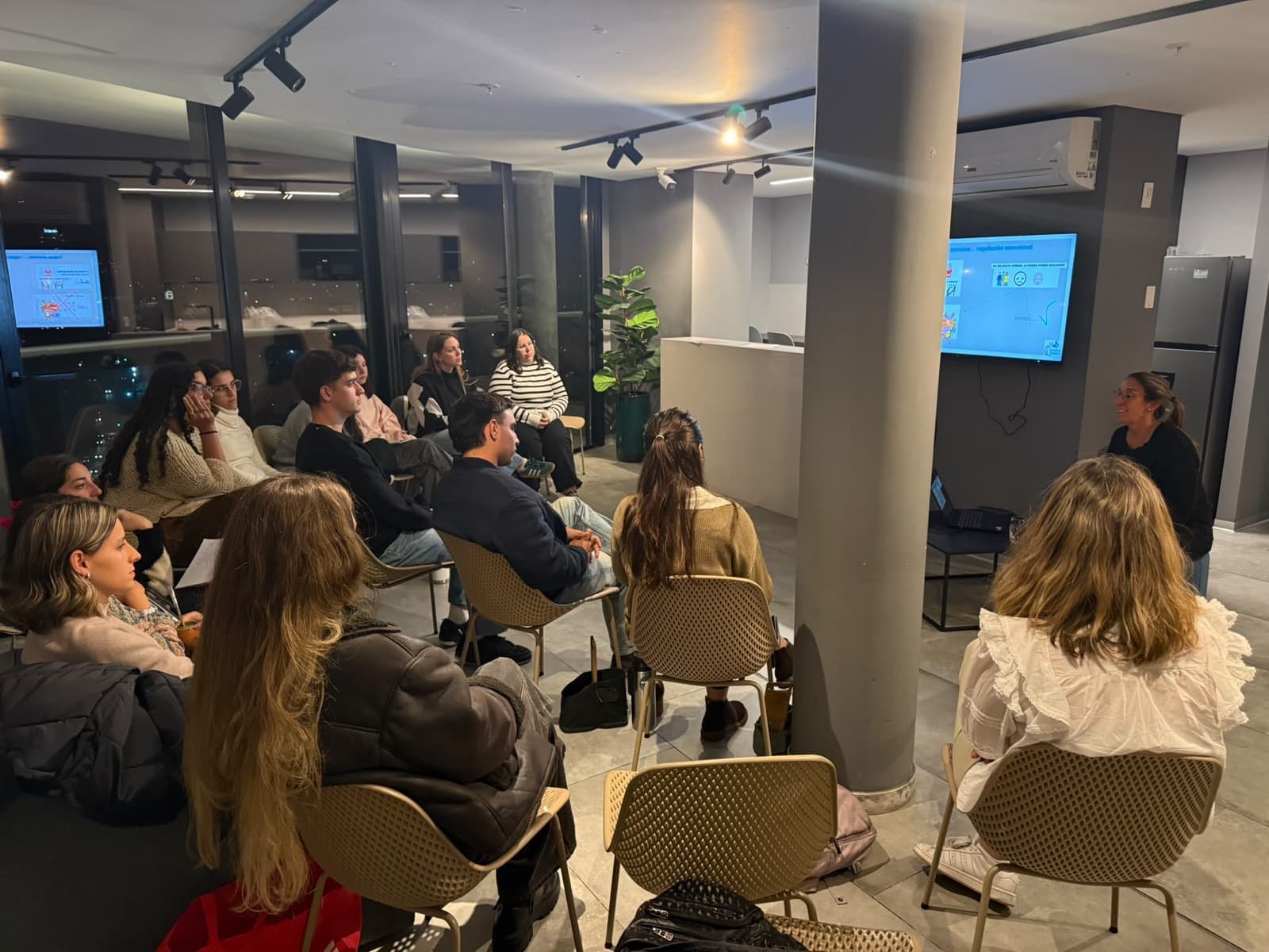 Acompañantes reunidos en una charla de formación, con una presentación en pantalla
